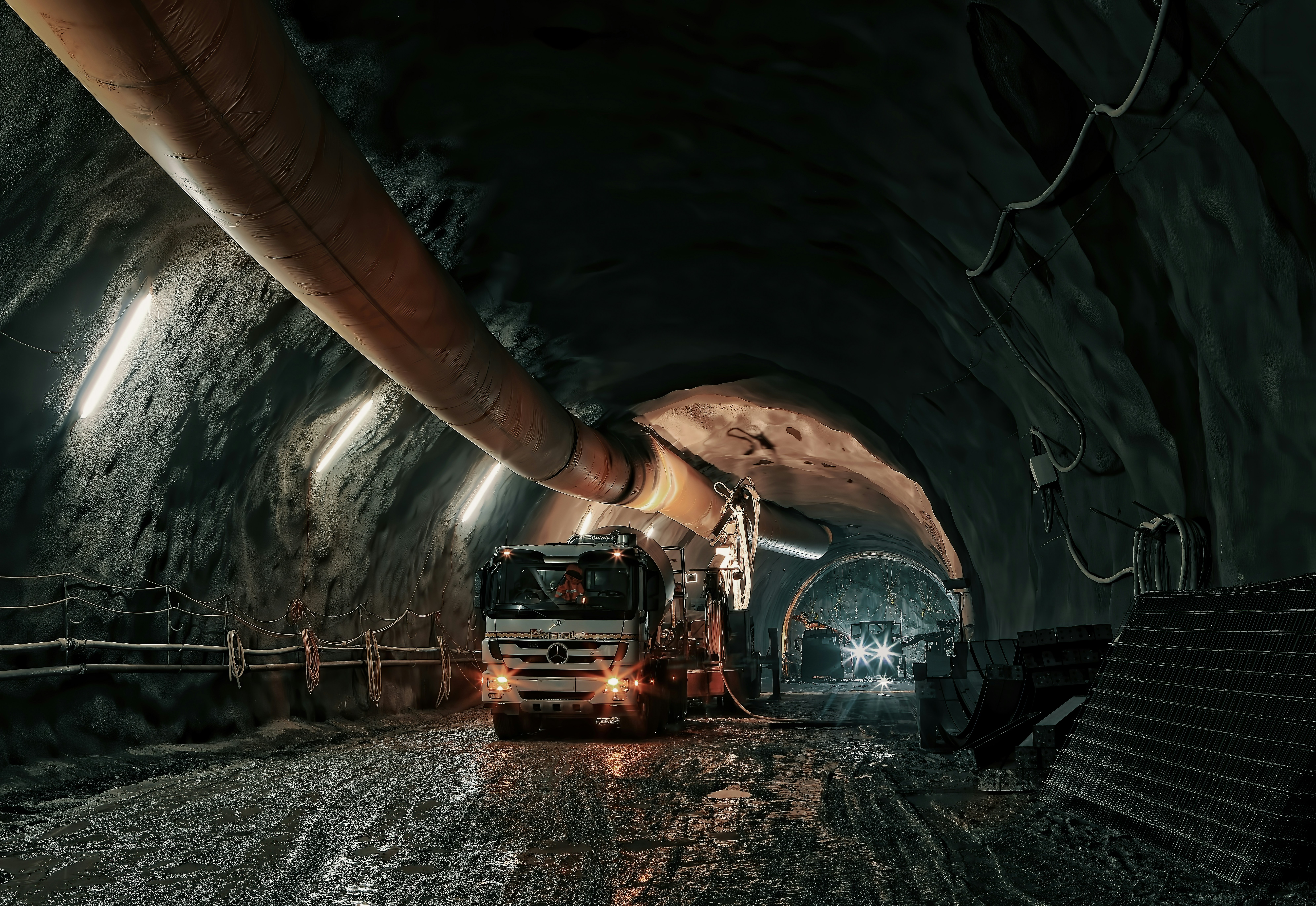 Ein LKW in einer großen Höhle in einem Bergwerk. Kein Tageslicht. Dreckige Umgebung.